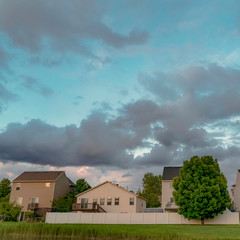 Square Scenic neighborhood with lovely homes and lush green trees under a cloudy sky