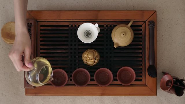 She gently poured the puer tea standing on the table cups. The view from the top