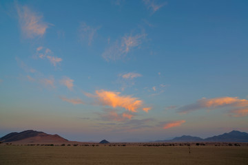 Fototapeta na wymiar Pink clouds in early morning light in the desert