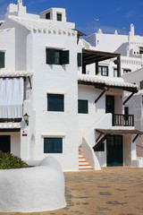 Street with white houses in Binibeca, fishing village in Menorca island, Spain