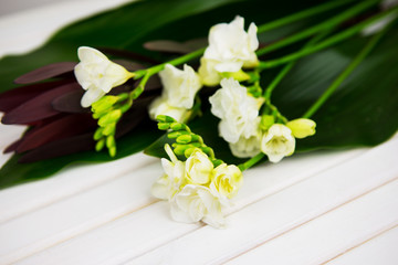 beautiful composition, a bouquet of freesia on a wooden table