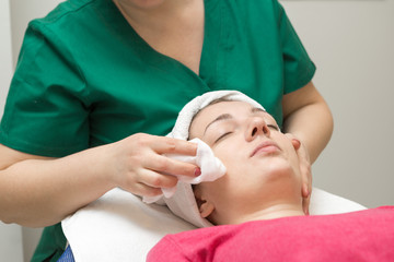 Face skin care. Beautician applying beauty oil mask on face using brush In spa salon	