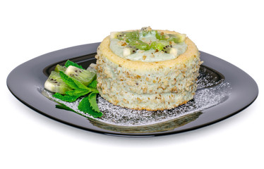 Sponge cake with cottage cheese and kiwi cream, decorated with pieces of fruits, ground walnuts, mint leaves and powdered sugar