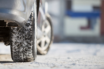 Close-up of car wheels rubber tire in deep snow. Transportation and safety concept.