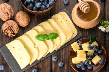 cheese, blueberries, and honey on a wooden background