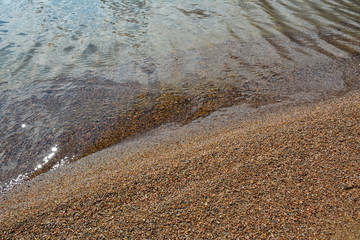 Transparent waves rush to the sandy beach