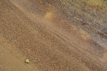 Waves rush to the brown beach