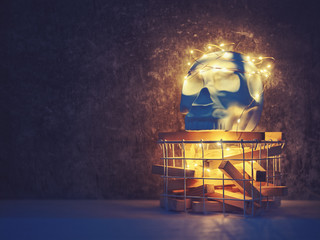 A decorative figure in the form of a human skull in blue is located on wooden bars located in a...