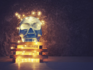 A decorative figure in the form of a human skull in blue is on a stand made of wooden blocks. A...