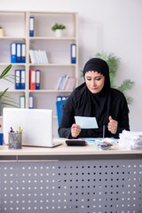 Female employee bookkeeper in hijab working in the office