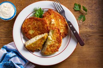 Potato Pancakes Filled With Cheese. Vegetable fritters stuffed with cottage cheese. View from above, top studio shot