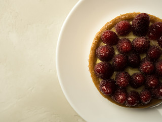 Overhead view of shortbread cake with raspberries against white background
