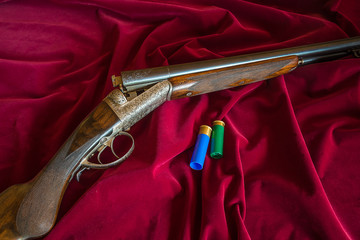 Beautiful hunting rifle on the red velvet background