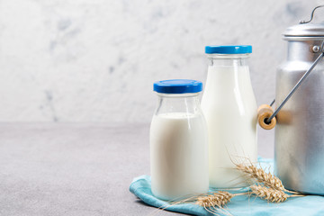 Bottles of fresh milk and aluminum milk can on a table