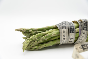 Asparagus surrounded by a medical tape on weighing scale for diets