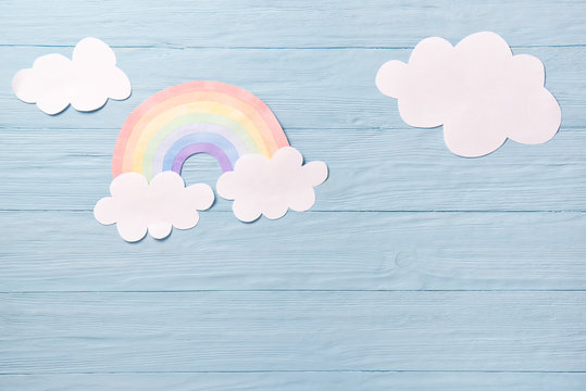 Fototapeta Children or baby background, white clouds with rainbow on the blue wooden background