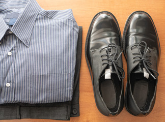 everyday set of mans wear clothes for white collar worker - pants, formal shirt and pair of glossy shoes