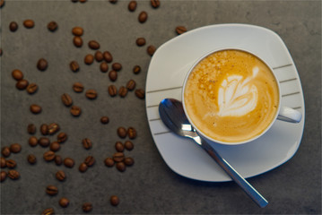 Cappuccino in weißer Tasse mit Bohnen
