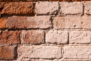 Old broken brick wall closeup of red and pink bricks. Texture