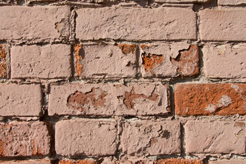 Old broken brick wall closeup of red and pink bricks. Texture