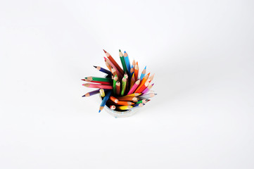 Colored pencils in a jar. View from above. White background. Free space for text.