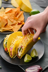 Hand taking a hard-shell taco