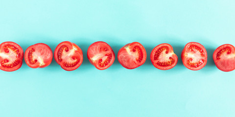 Tomato pattern. Frame made of fresh half tomatoes on light blue background. Flat lay, top view, copy space