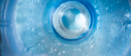 Long background with plastic blue bottle surface with water droplets