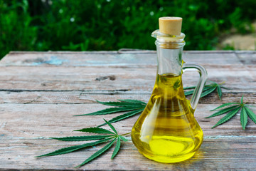 Cannabis oil in a bottle on a wooden background.