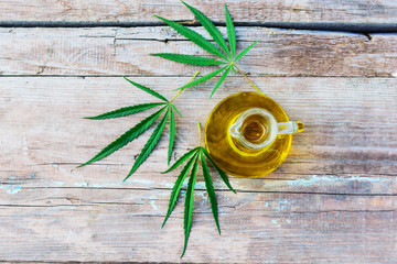 Cannabis oil in a bottle on a wooden background.