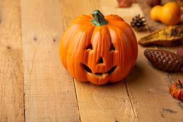 Halloween pumpkin with leaves on an old wooden table. View from above. Copy space. Autumn mood