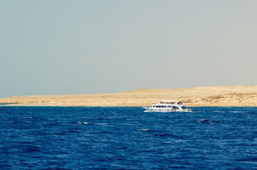 Naklejka premium White pleasure boat on the background of the nature reserve of the Ras Muhammad