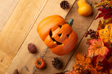 Halloween pumpkin with leaves and pine cones and elements of decor on an old wooden table. View from above. horizontal frame, with space, autumn mood