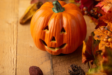 Halloween pumpkin with leaves on an old wooden table. View from above. Copy space. Autumn mood