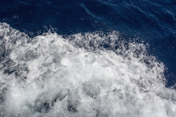 Fototapeta na wymiar White sea foam marine blue water boat wake