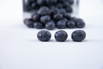 Tasty blueberries - Pile of freshly harvested ripe blueberries on a white background - Large, sweet wet blueberries on a white table