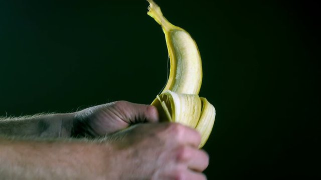 Hand peeling a banana fruit
