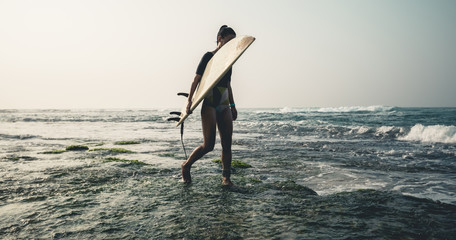 Woman surfer with surfboard going to surf