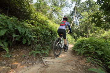 Cross country biking riding mountain bike in the action on tropical rainforest trail