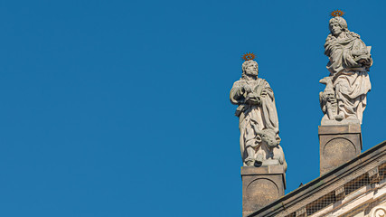 Decorative facade statues of priests and bishops at Saint Salvator church near Charles Bridge in Prague, Czech Republic, summer time, details