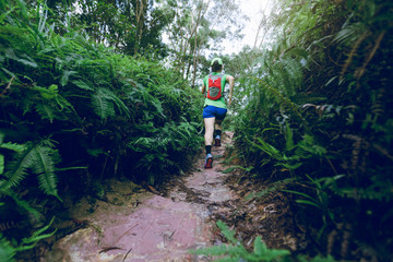 Obraz premium Woman ultra marathon runner running on tropical rainforest trail