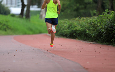 Fitness sporty woman jogger running at outdoors jogging track in park