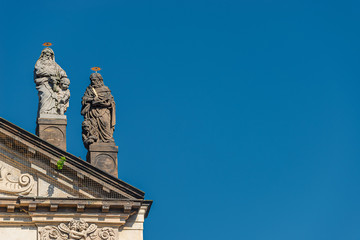 Decorative facade statues of priests and bishops at Saint Salvator church near Charles Bridge in Prague, Czech Republic, summer time, details