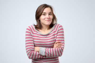 Happy cheerful young woman looking at camera with joyful and charming smile. Positive facial human emotion. Studio shot.