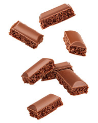 Falling porous chocolate pieces, isolated on white background, clipping path, full depth of field