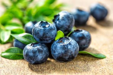 Fresh whortleberry with a green leaf on old wood background.Healthy eating and nutrition.