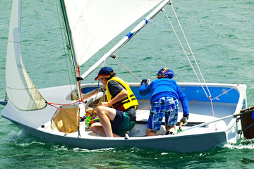 Two Boys Sailing in a small boat on salt water.