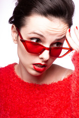 young woman in red sunglasses, red nails, red lipstick