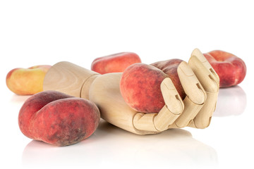Group of four whole fresh red peach prunus persica platycarpa in wooden hand isolated on white...