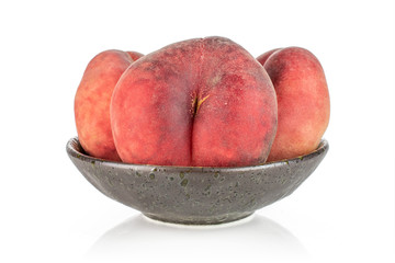 Group of three whole fresh red peach prunus persica platycarpa in dark ceramic bowl isolated on white background